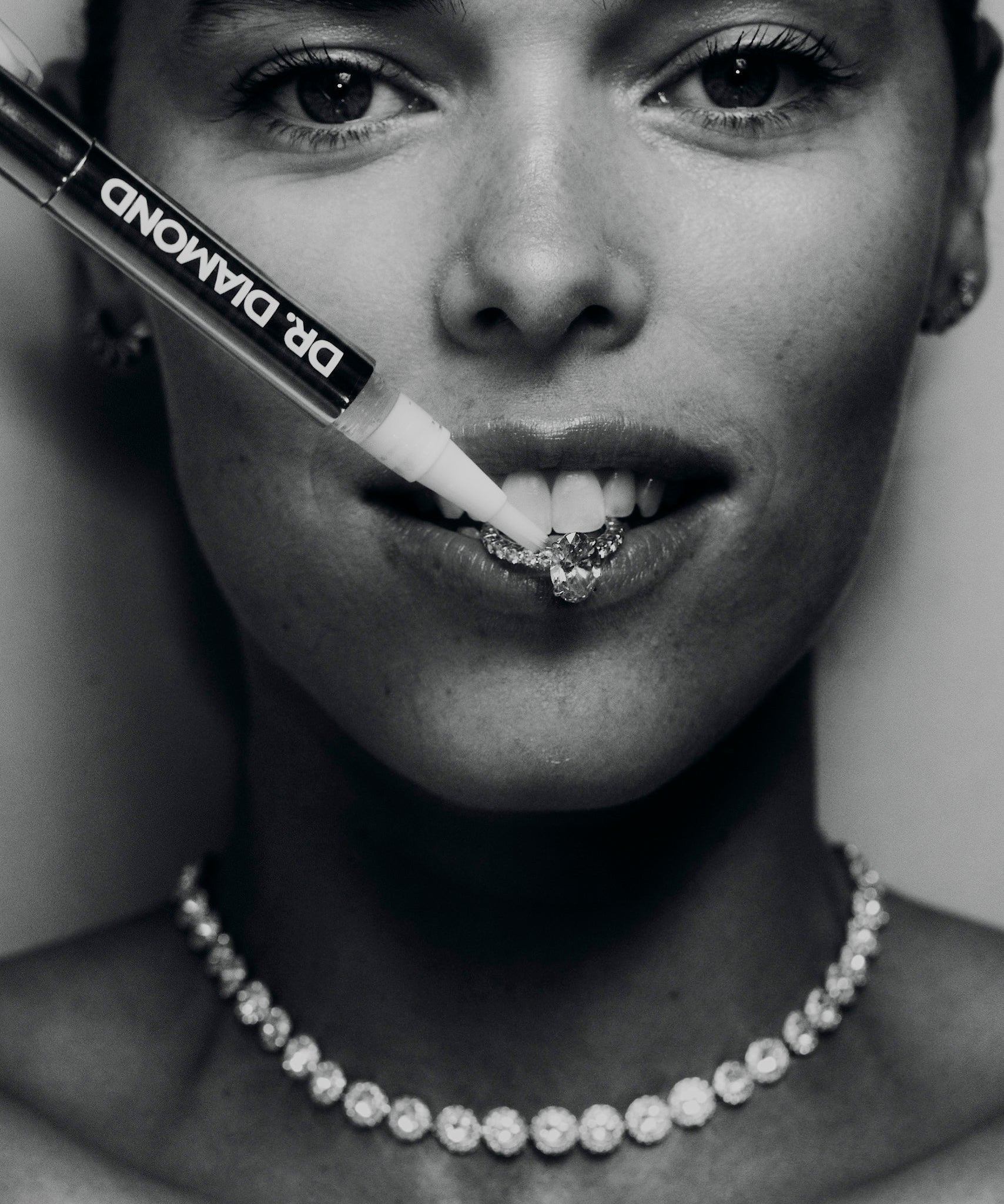 drdiamondcleaningpencleaningdiamondengagementringinmouthofwomaninblackandwhite